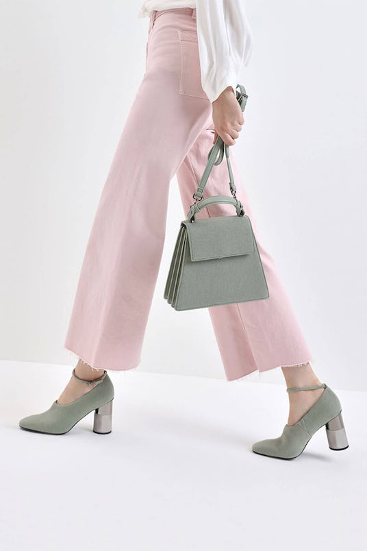A model carrying a Charles & Keith angular top handle felt bag and concrete heel fall ankle boots, b...