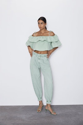 A model wearing a pistachio ruffled top from Zara and matching pants 