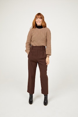 A model in a brown Frances Austen cashmere sweater and brow pants 