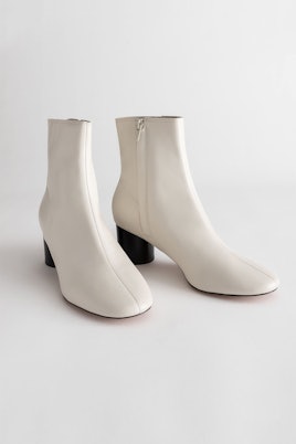 White leather ankle boots with a short black heel