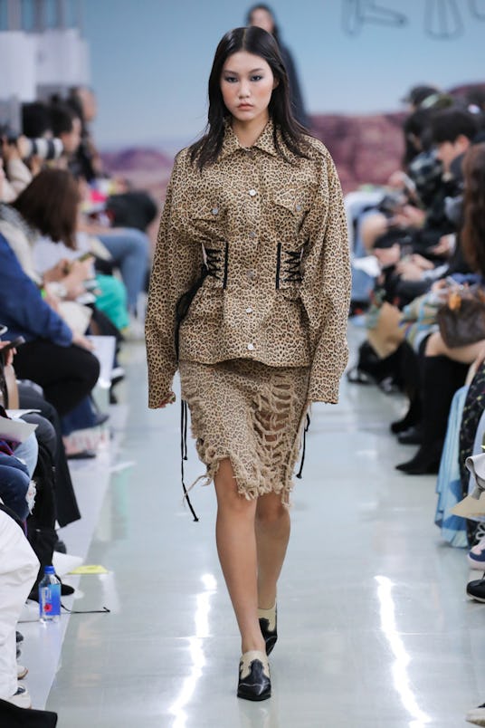 A female model walking a runway for the popular streetwear Korean brand ''KYE'' while wearing a brow...