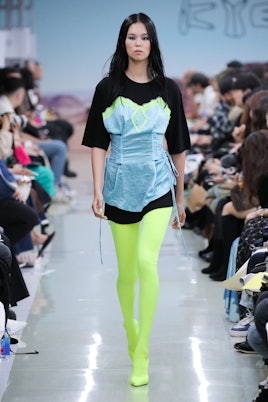 A model walking a runway for the streetwear Korean brand ''KYE'' while wearing an extravagant black ...