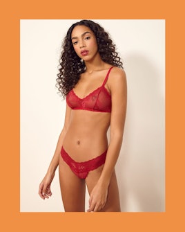 The model wearing red lace Costa bra and Helena thong by Reformation.
