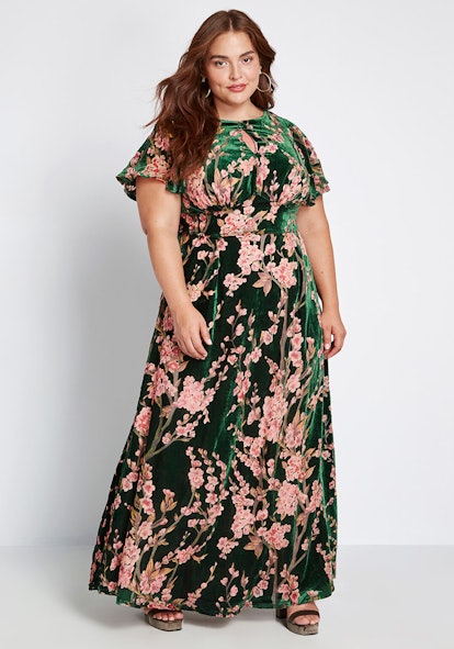 A brunette model in Modcloth, Soiree Saunter Velvet Maxi Dress that is in a floral print