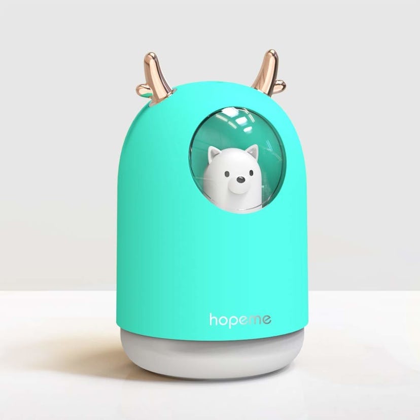HOPEME's Cool Mist humidifier in turquoise, with golden reindeer antlers and a white dog inside 