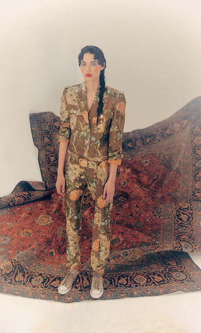 Fashion designer Mia Vesper's flower print suit in front of a tapestry background