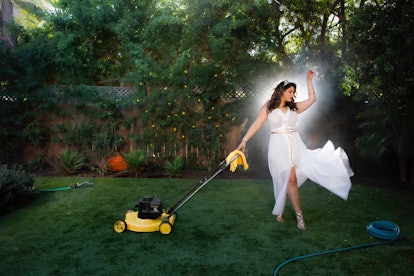 Denise Bidot dancing in a white shapewear dress in her garden