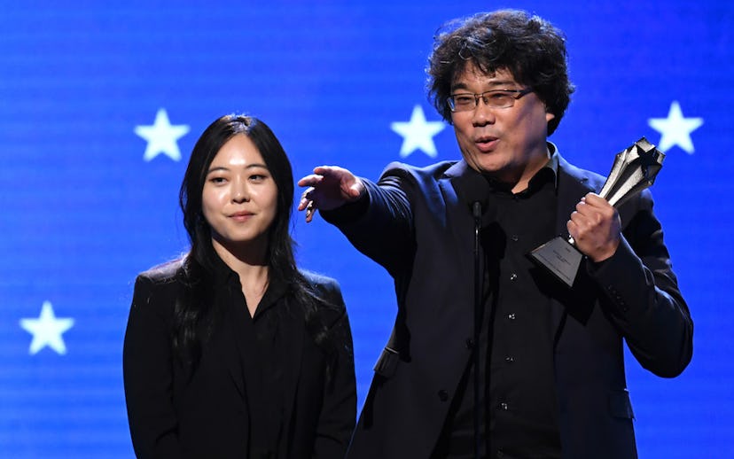 Interpreter Sharon Choi (L) and director Bong Joon-ho accept the Best Director award for 'Parasite' ...