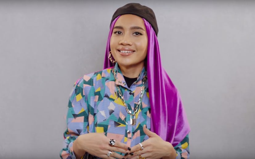 Yuna wearing a purple scarf and a black hat on her head