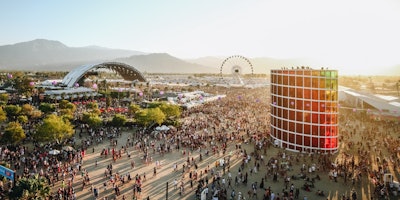 Coachella event showing off a stage, ferris wheel and a crowd of people