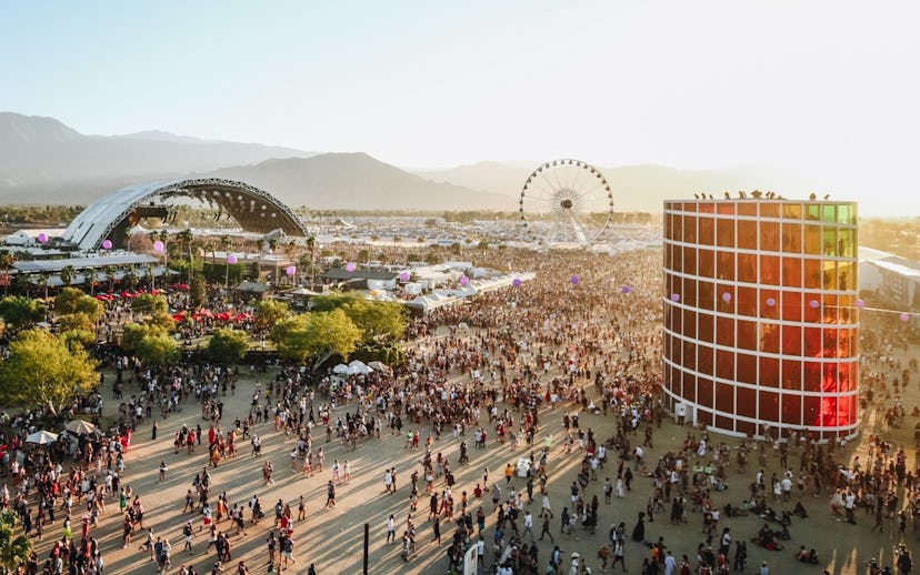 A stage, Ferris wheel and a crowd of people entering Coachella