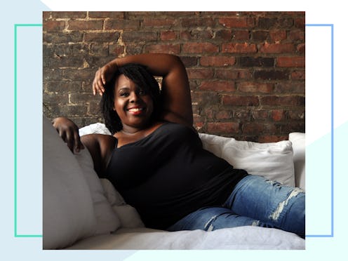 CeCe Olisa sitting on a couch with her legs up wearing a black top and jeans smiling at the camera