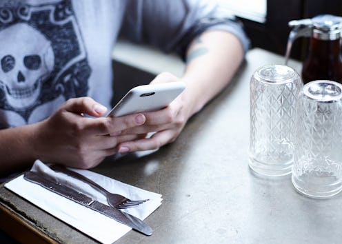 A man in a coffee shop using the magnifier in iOS 10