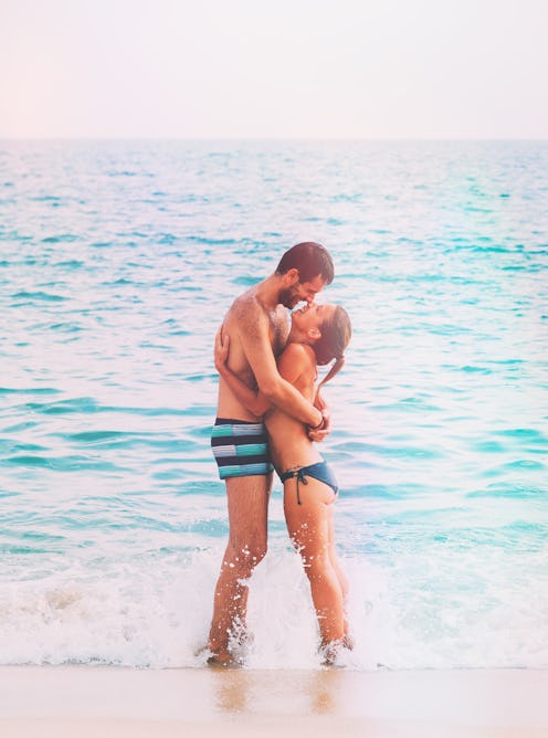 Couple kissing by the sea at their vacation