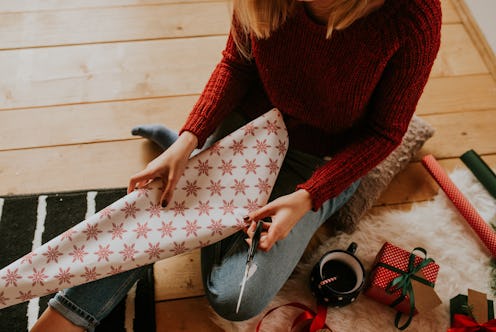 A girl cutting gift package paper