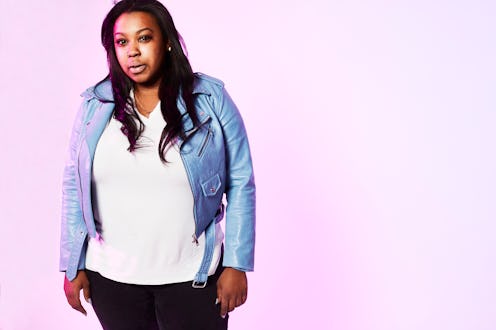 A grown-ass woman posing in a white shirt and light blue jacket