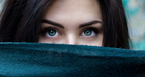 A woman with possible undiagnosed addiction hiding her face behind a scarf.