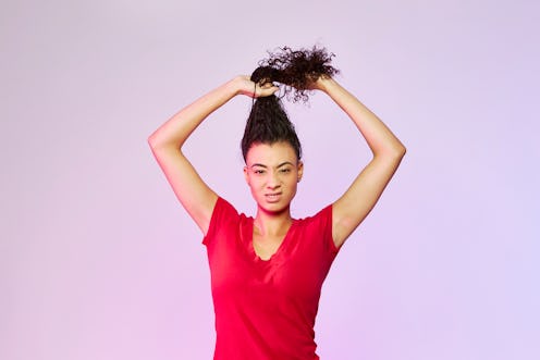 A woman holding her hair as she is going to make a bun