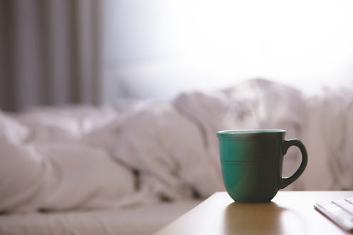 A turquoise cup of hot drink on a brown table