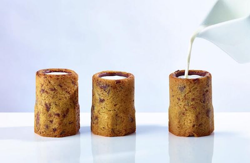 Three cookie shot glasses being filled with milk