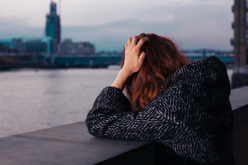 A woman depressed due to STI standing lonely and sadly next to a river