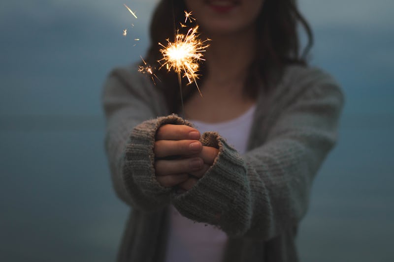 A woman holding a sprinkle as a way to celebrate Fourth of July Alone