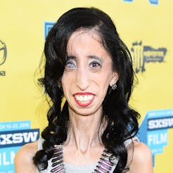 Lizzie Velasquez in a beige top and large necklace on a red carpet event