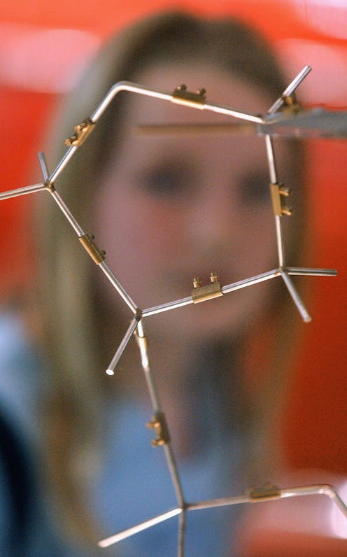 A blurry image of a woman in front of a representation of molecules