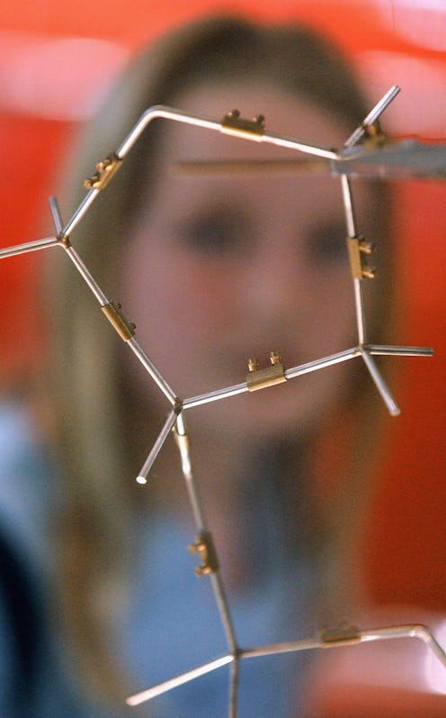 A blurry image of a woman in front of a representation of molecules