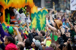 A woman catches beads at a Mardi Gras parade. Why do women flash their breasts for beads during Mard...