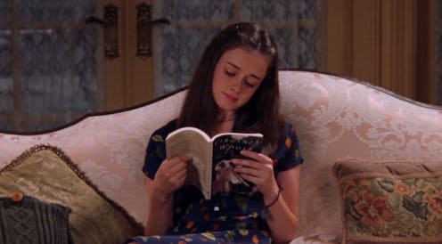 Young girl sitting alone and reading a book