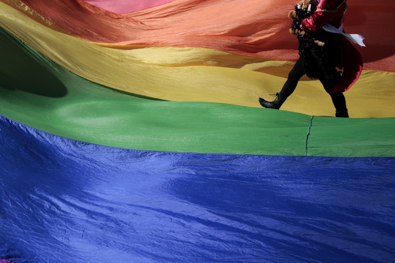 Teen Kinzey Ratzman walking on the rainbow pride flag.