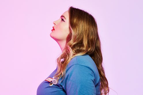 A woman with a long brown hair, in a blue T-shirt looking up