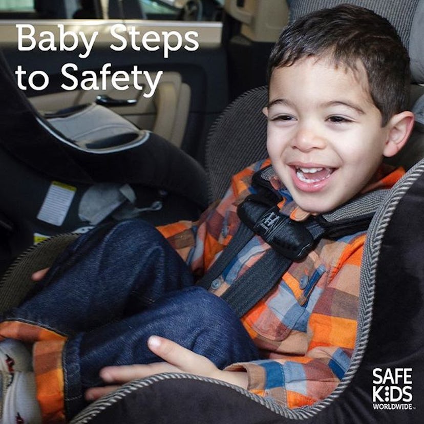 A boy sitting in a car seat and smiling 