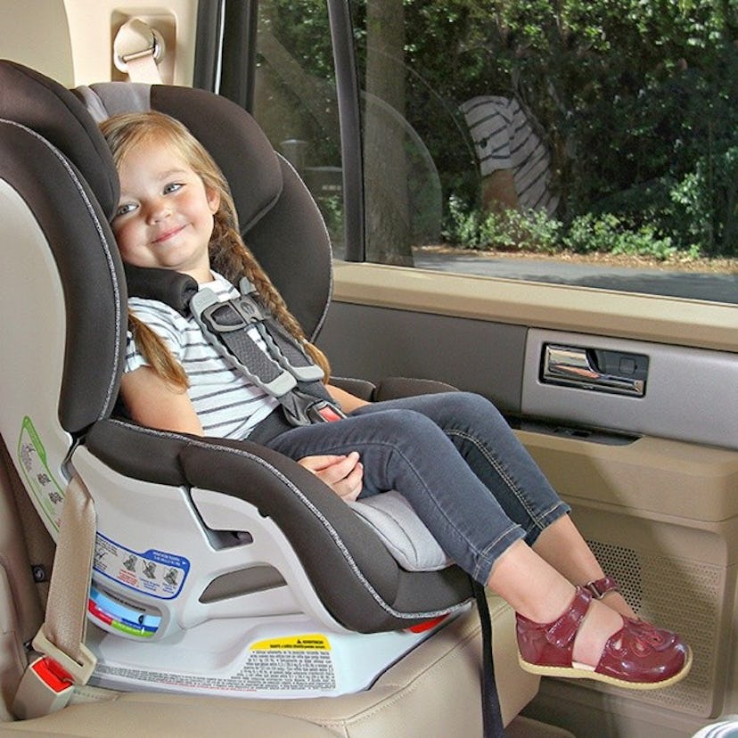 A girl sitting in a properly secured car seat 