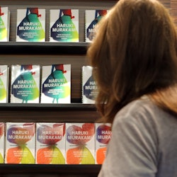 A woman looks at books for sale by Haruki Murakami.