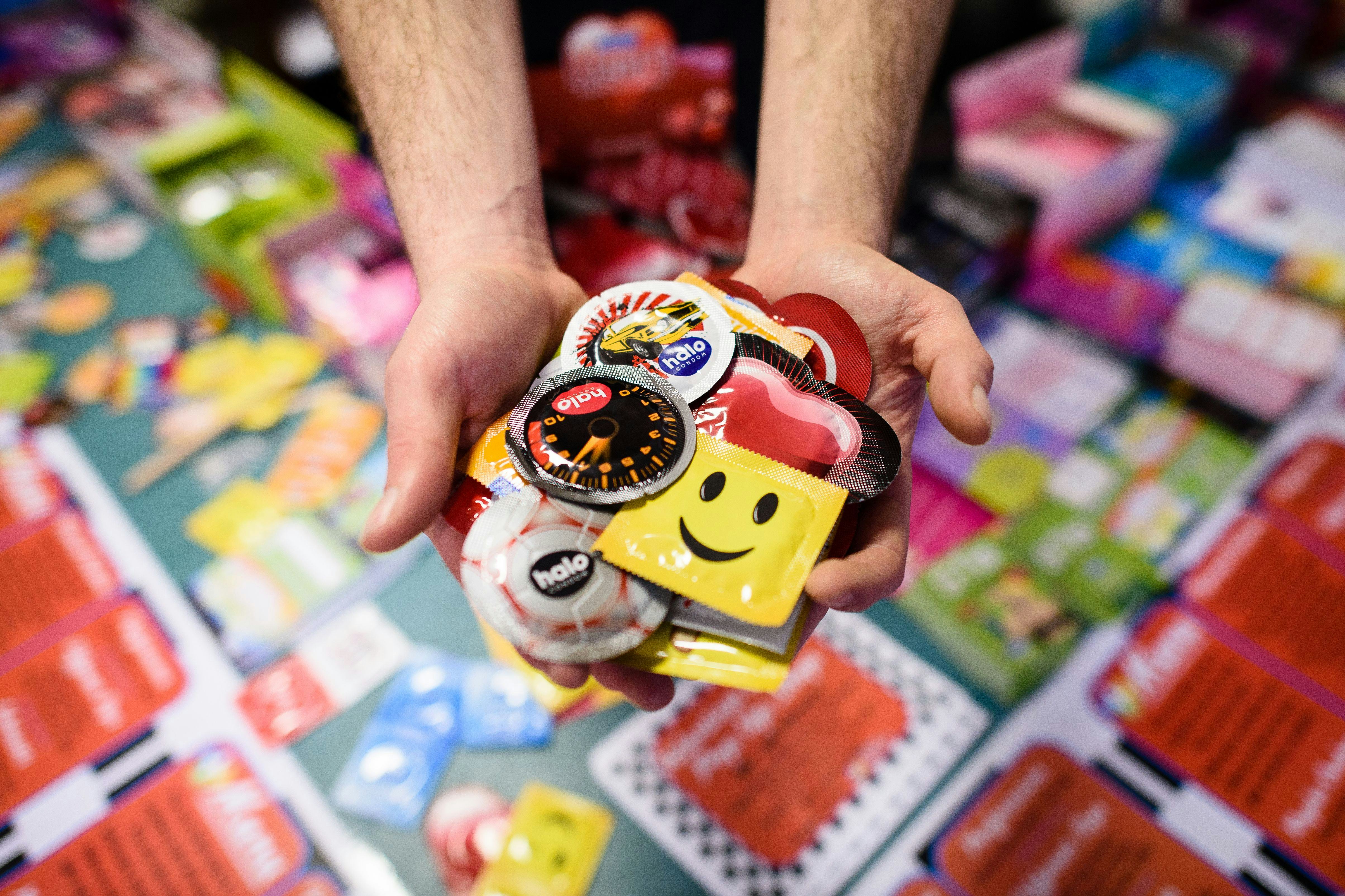 Hands full of various condoms