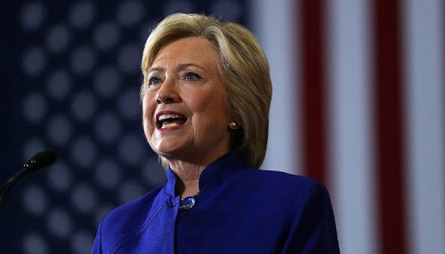 Hilary Clinton, in a blue blazer giving a speech.