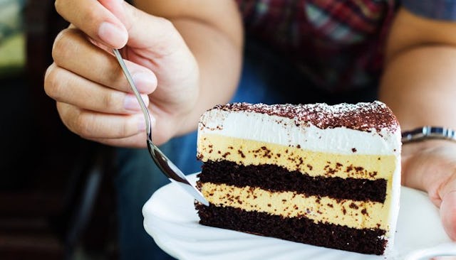 A person eating a chocolate cake with a spoon