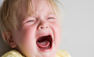 A toddler with blond hair crying with his mouth wide open.