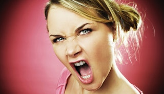 Angry pregnant blonde woman wearing a pink shirt with a face that looks like she is yelling