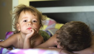 The first and the second child laying in the bed 