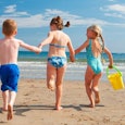 Small four kids running into the sea