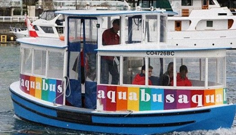 People sitting on the Aquabus, rainbow lines are on the lower part of the boat in Vancouver