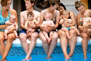 Annoying moms and dads sitting on the edge of the pool holding their babies 