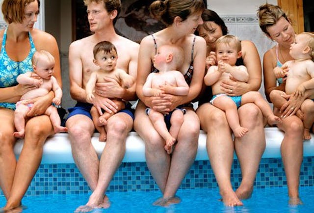 Annoying moms and dads sitting on the edge of the pool holding their babies
