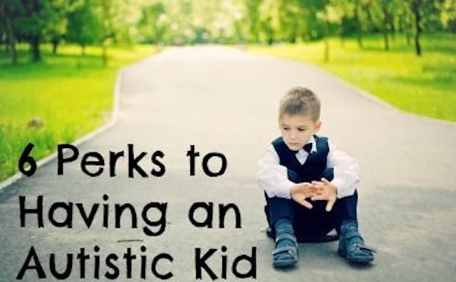 An autistic kid in a school uniform sitting on the pavement at the park