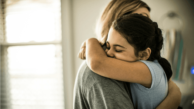 A young daughter giving her mother a big hug 