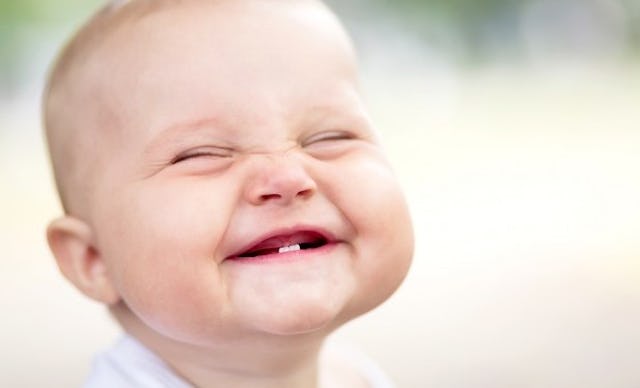 A baby who is very happy and smiling because of weaning