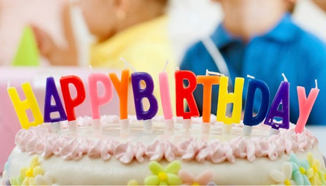 A birthday cake with candles spelling out Happy Birthday